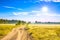 Summer rural landscape with a field, sunrise and road