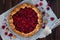 Summer rustic raspberry galette on white vintage wooden table. Top view.