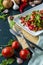 summer salad, tomatoes, green peas, arugula, onion, olive oil, garlic, hot pepper fork knife bamboo cutting board pastel green