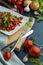 summer salad, tomatoes, green peas, arugula, onion, olive oil, garlic, hot pepper fork knife bamboo cutting board pastel green