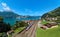 Summer scenery of beautiful Lake Lucerne on a sunny day, with a train traveling on the railway thru Sisikon Village