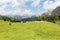 Summer scenery of a beautiful ranch in a grassy valley in Dolomites with cattle grazing on green meadows