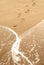 Summer sea, footstep and foam on sand, vertical background