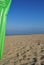 Summer sea, plastic green inflatable mat on the beach, vertical