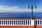 Summer seafront with street lamp and vintage fence in Canico, Madeira.