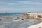 Summer seascape. Coastline in small italian town Livorno. View from waterfront. Selective focus on rocks