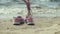 Summer shoes on the beach. in the background of a girl walking and dancing on the sand