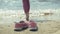 Summer shoes on the beach. in the background of a girl walking and dancing on the sand