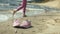 Summer shoes on the beach. in the background of a girl walking and dancing on the sand