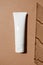 Summer skincare sunscreen cosmetic product mockup on beige sand color background and trendy shadow, vertical. White plastic cream