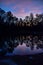 Summer sky and trees reflected in lake water