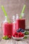 Summer smoothie in glass jar with berries plates.