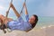 Summer solar portrait of fashion of a way of life of the young stylish woman,sitting on a swing on the beach,carrying lovely fashi