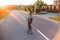 Summer sport and active lifestyle. Cool young girl skater riding skateboard on the street by sunset. Outdoor.
