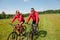 Summer - Sportive couple riding bike in meadow