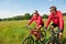 Summer - Sportive couple riding bike in meadow