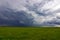 Summer Storm clouds above meadow with green grass Rising Thunderstorm