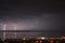 Summer storm over Adriatic Sea with two thunderstorm and city of Rijeka by night