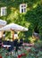 Summer street cafe interior with white umbrella in green city park, ornate with flowers and decorative elements