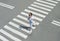 In the summer on the street at the pedestrian crossing kid girl in fashion clothes cross the road. From top view. Shadow at zebra