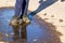 Summer stroll kid in shoes in puddle.