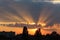 Summer sunset with dark sky and sun beams