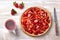 Summer tart with custard of baked milk, juicy fresh strawberries and a cup of tea on a light wooden background