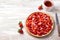 Summer tart with custard of baked milk, juicy fresh strawberries and a cup of tea on a light wooden background