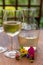 Summer tasting of cold white wine on sunny garden terrace with wooden pergola