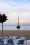 A summer terrace seaside view on traditional european mediterranean restaurant, a yacht at the sky background