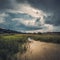 Summer thunderous countryside landscape with a river, water, forest and dark dramatic clouds