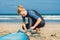 Summer time and active rest concept. Young surfer woman beginner fastens leash across leg, going to surf on big barral