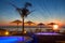 Summer time: beautiful dawn at pool area with palm and parasols, Tropea, Italy