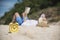 Summer time Handsome man vacation on the beach. Cheerful man lay down on summer beach wear straw hat reading a book. Time to relax