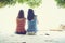 Summer time, Portrait of two young women sitting back on the beach.