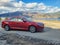 Summer time and red car on beautiful nature at the background. Red car parked in the park with mountains and lake