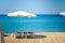 Summer time resort hotel beach coast line scenic landscape view of umbrella lounge furniture deck chair on wooden deck floor and