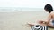 Summer time woman bikini use sunscreen lotion spf sunblock on the beach. Cheerful woman wear white bikini, short pant, straw hats