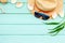 Summer travaling to the sea with straw hat, sun glasses, shells on mint green wooden background top view mock up