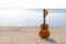 Summer traveling with guitar and Fashion woman hat on the sand beach in the holiday, sunset beach background.