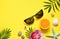 Summer Tropical Background. Palm Trees Branches, starfish and seashell on yellow background. Summer concept.Travel.