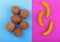 Summer tropical fruits. Whole and organic coconuts on a blue background and bright yellow bananas on a bright pink background.