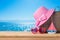 Summer vacation concept with suitcase, sunglasses, hat and boat over sea beach background