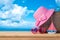 Summer vacation concept with suitcase, sunglasses, hat and boat over sea beach background