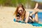 Summer vacation Girl with phone tanning on beach