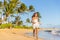 Summer vacation happy Asian woman running carefree on beach during Hawaii travel on Maui island wearing white dress at