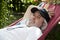 summer vacation. Leisurely retreat for the old man in his hammock. Relaxed old man lounging in a hammock. Tranquil moments for the