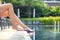 Summer vacation in the pool in a resort. Woman legs lying and relaxing on deck chairs