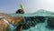 Summer vacation snorkeling in the ocean near the diving reef. A masked tourist looks at the sandy bottom under water