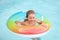 Summer vacation. Summertime kids weekend. Boy in swiming pool. Funny boy on inflatable rubber circle at aquapark.